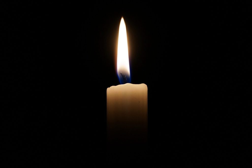 a single candle flame against an all black background
