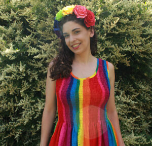 Jessica Leza outdoors with rainbow dress and flower crown.